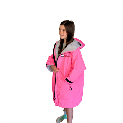 a little girl in a pink rain coat